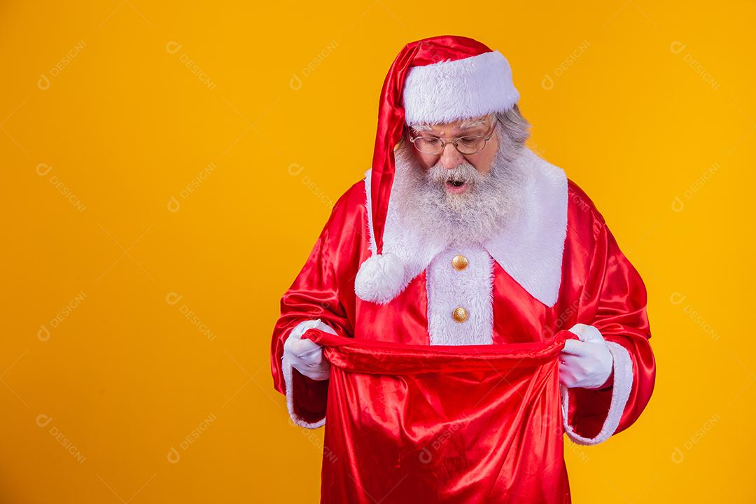 Curioso Papai Noel olhando para o saco de presentes