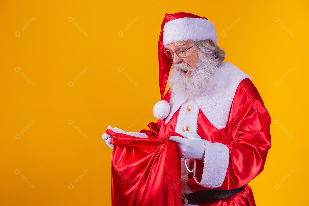 Curioso Papai Noel olhando para o saco de presentes
