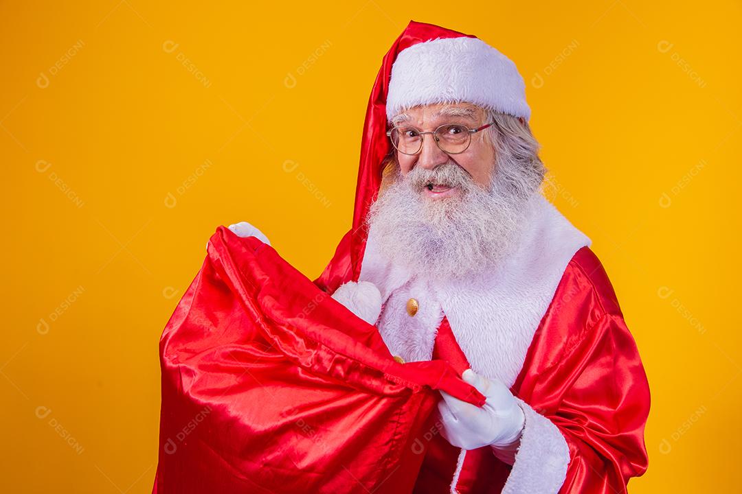 Curioso Papai Noel olhando para o saco de presentes