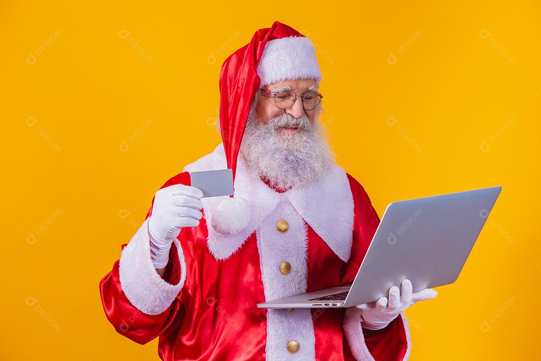 Papai Noel Mostrando um cartão e numa chamada no Laptop