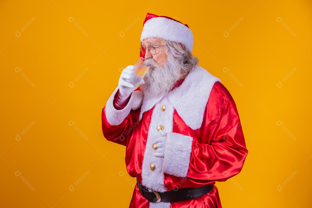 Papai Noel bebendo um copo de água no fundo amarelo