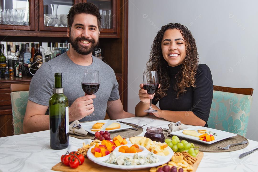 Casal no jantar romântico degustação de vinho e queijo.