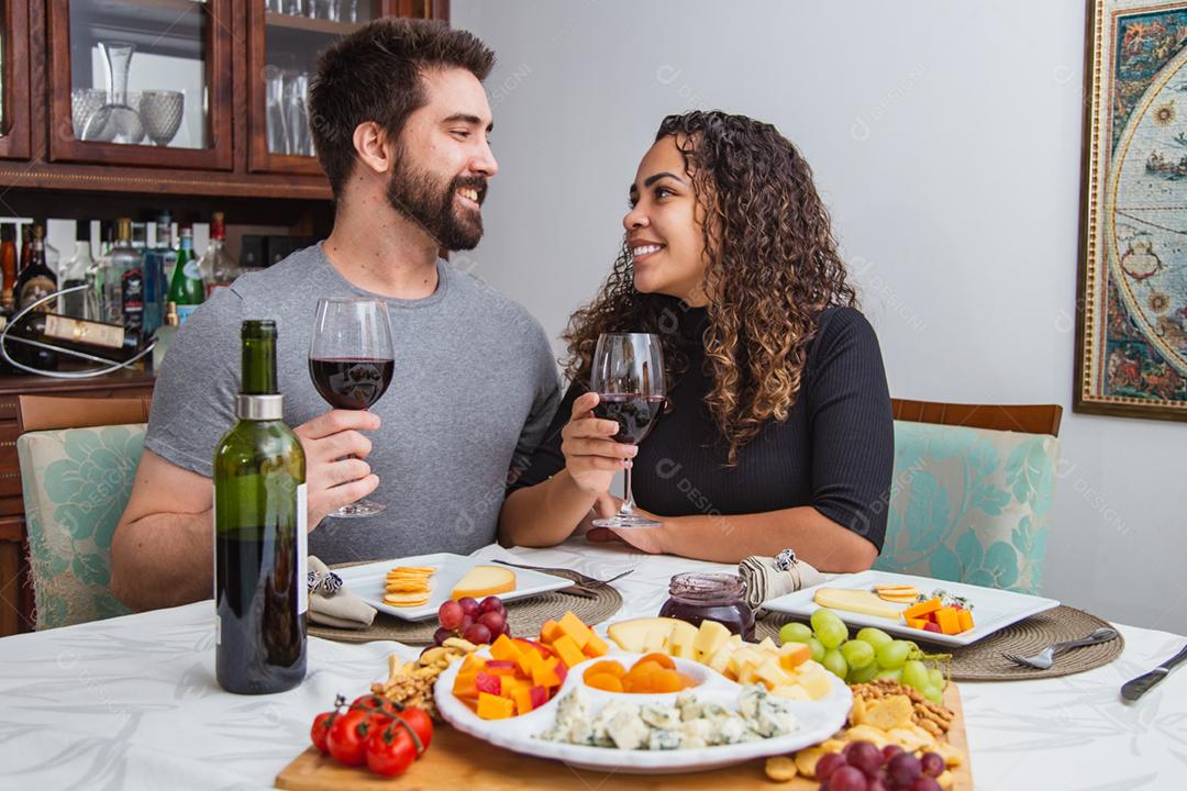 Casal no jantar romântico degustação de vinho e queijo.