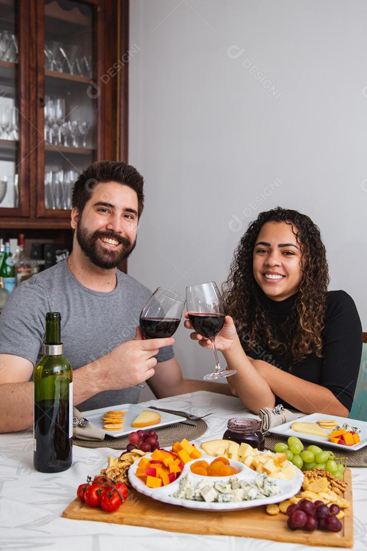 Casal no jantar romântico degustação de vinho e queijo.