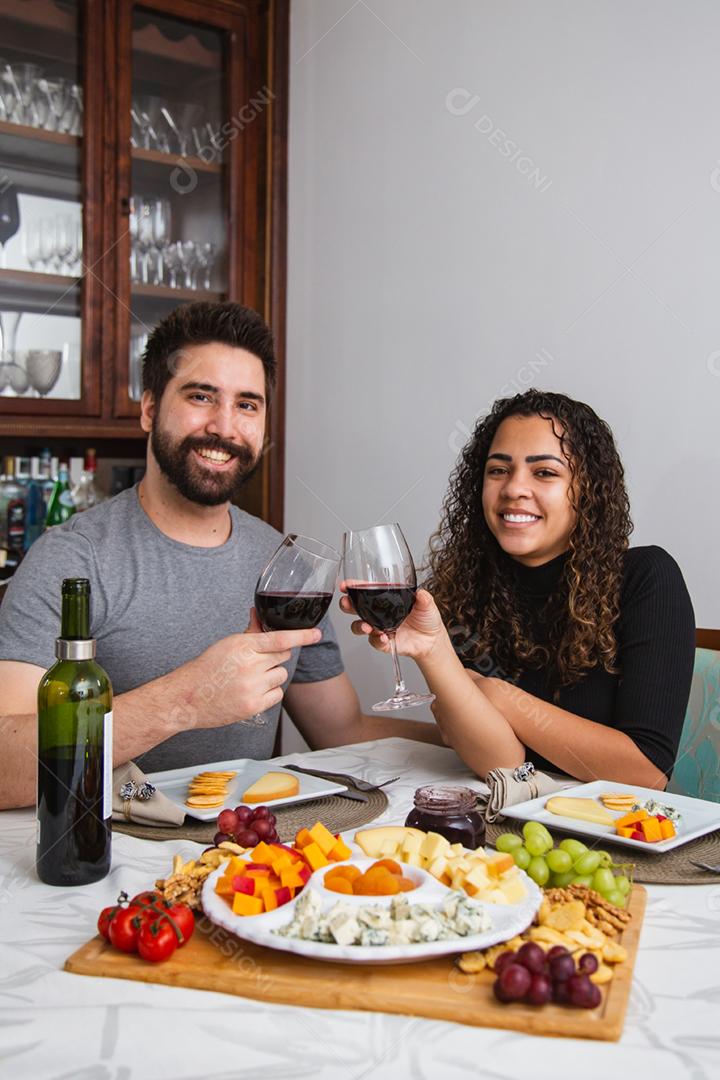 Casal no jantar romântico degustação de vinho e queijo.