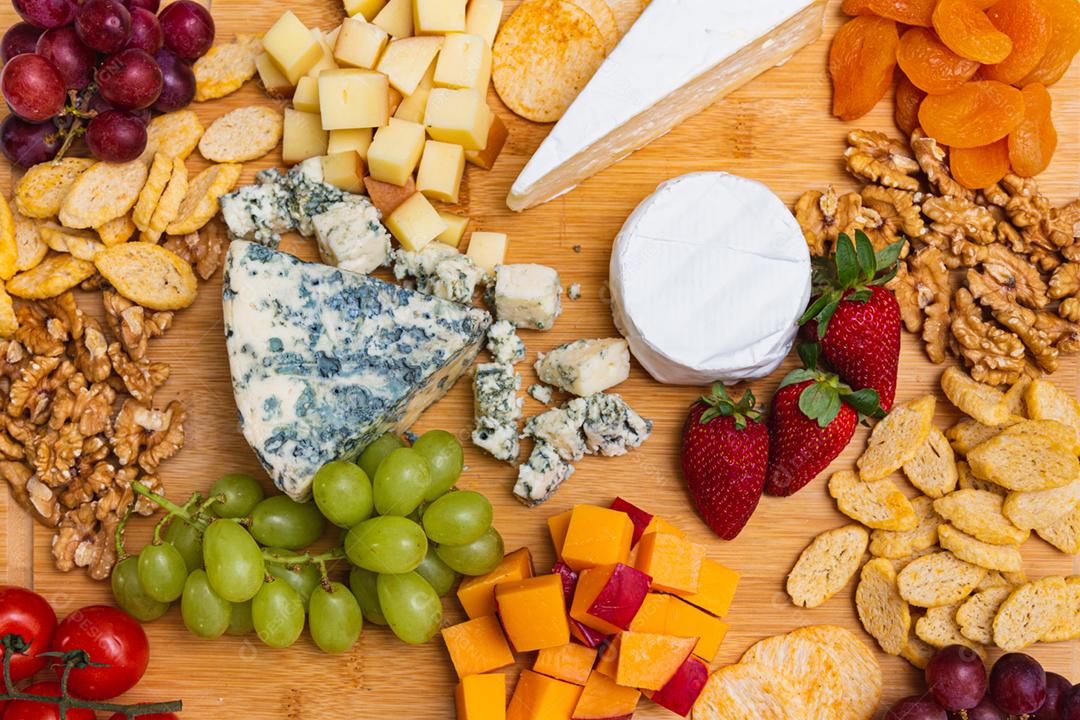 Prato de queijo com variedade de aperitivos na mesa.