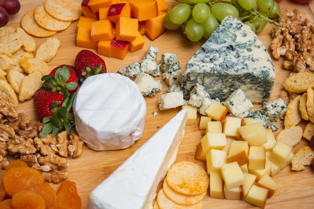 Prato de queijo com variedade de aperitivos na mesa.