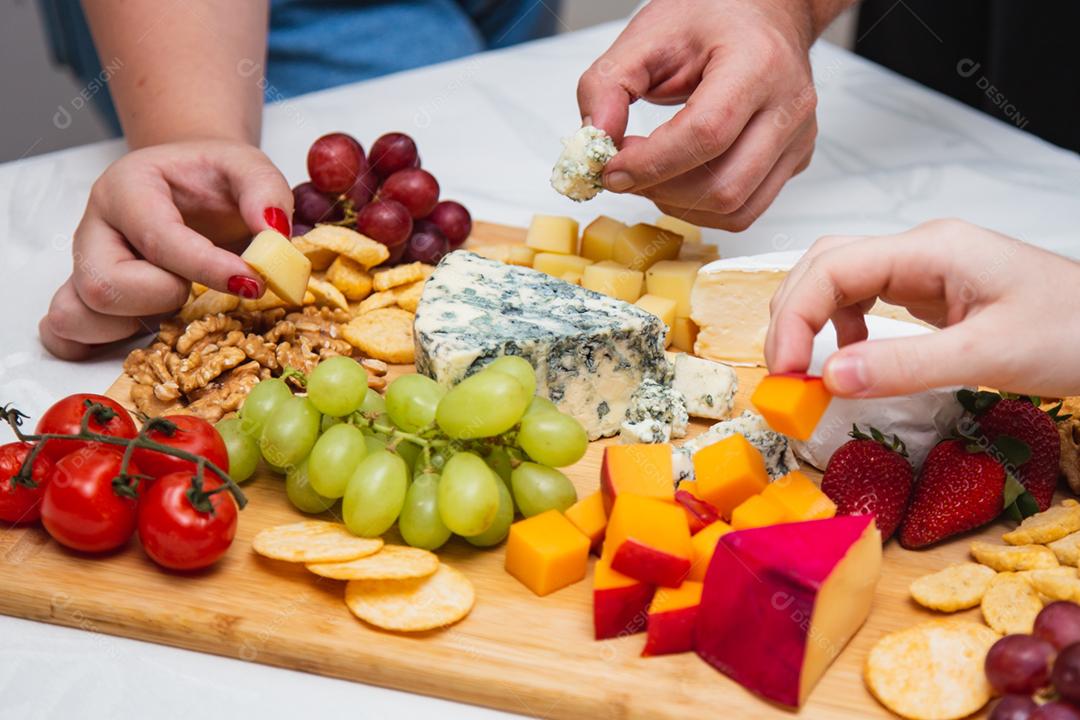 mãos de pessoas colhendo queijo de pestos