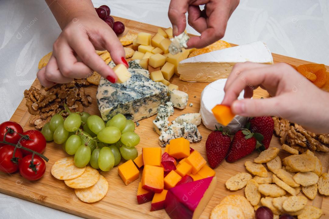 mãos de pessoas colhendo queijo de pestos