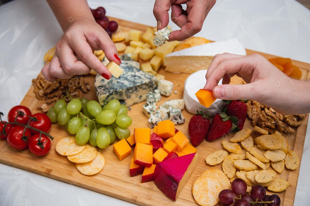 mãos de pessoas colhendo queijo de pestos