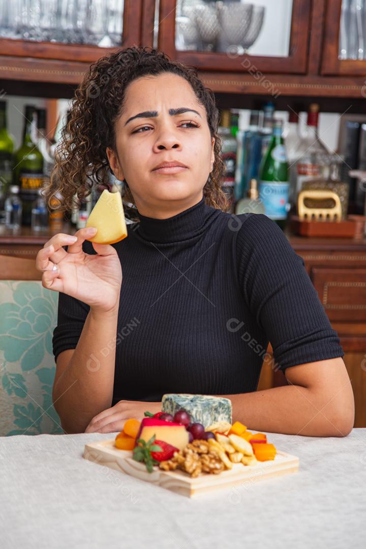 jovem bebendo vinho e comendo queijo sozinho na vida