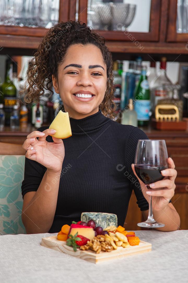 jovem bebendo vinho e comendo queijo sozinho na vida