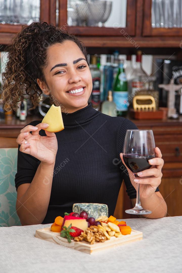 jovem bebendo vinho e comendo queijo sozinho na vida