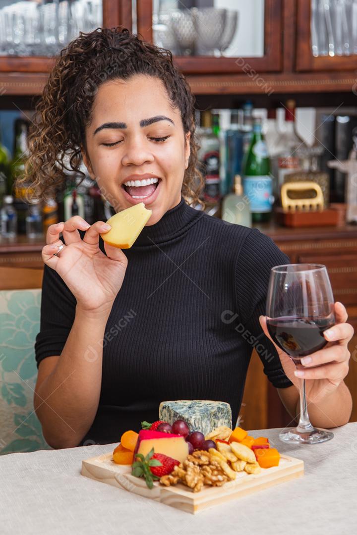 jovem bebendo vinho e comendo queijo sozinho na vida