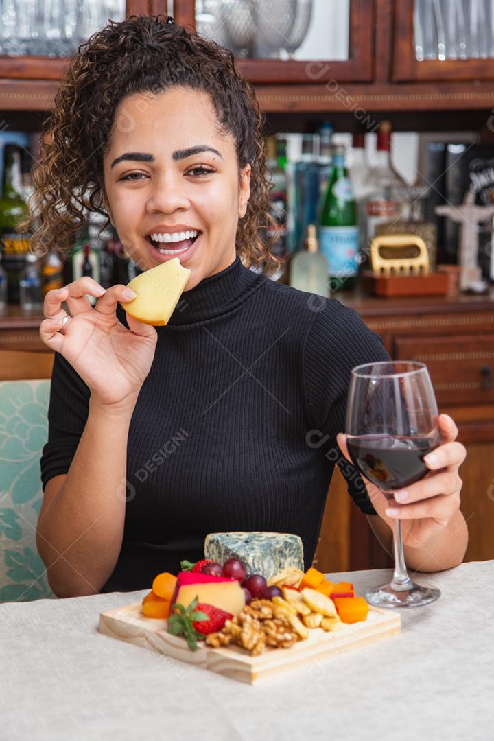 jovem bebendo vinho e comendo queijo sozinho na vida