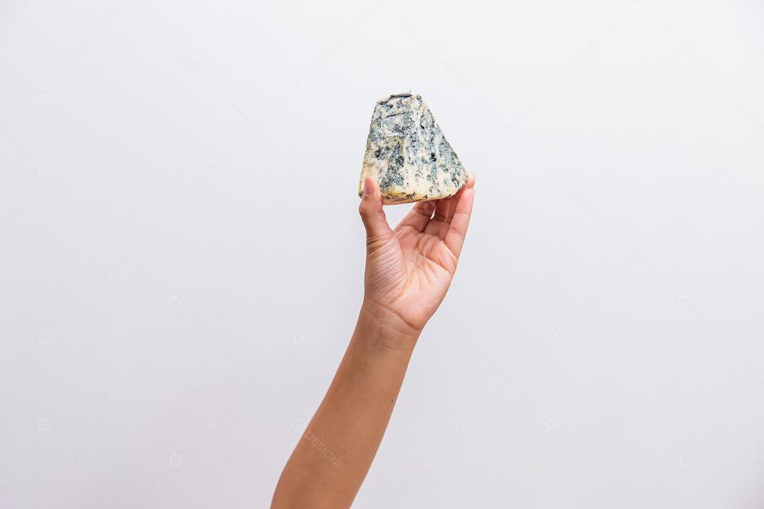 mão segurando um pedaço de queijo gorgonzola
