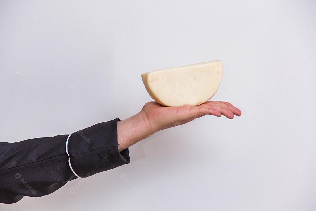 Mão segurando um pedaço de queijo .