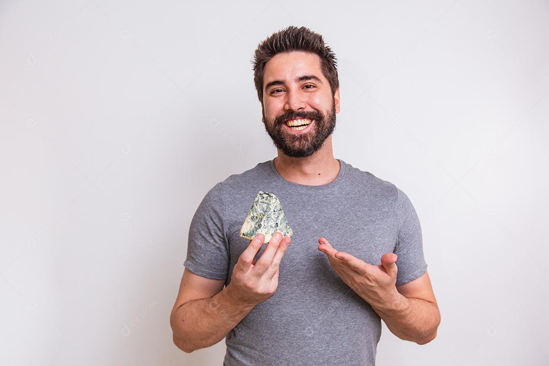 homem provador de queijo segurando um pedaço de gorgonzola no fundo branco.