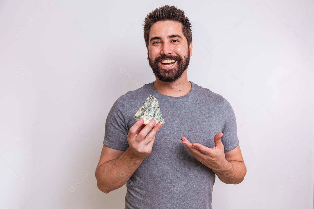 homem provador de queijo segurando um pedaço de gorgonzola no fundo branco.