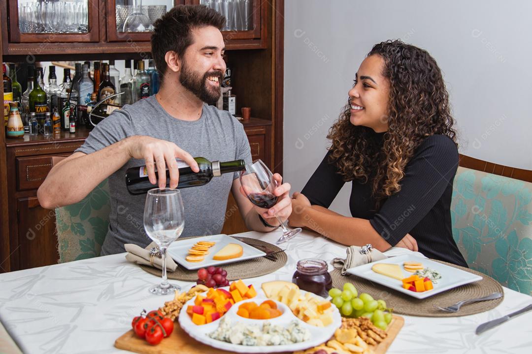 casal em jantar romântico degustação de vinho e queijo.