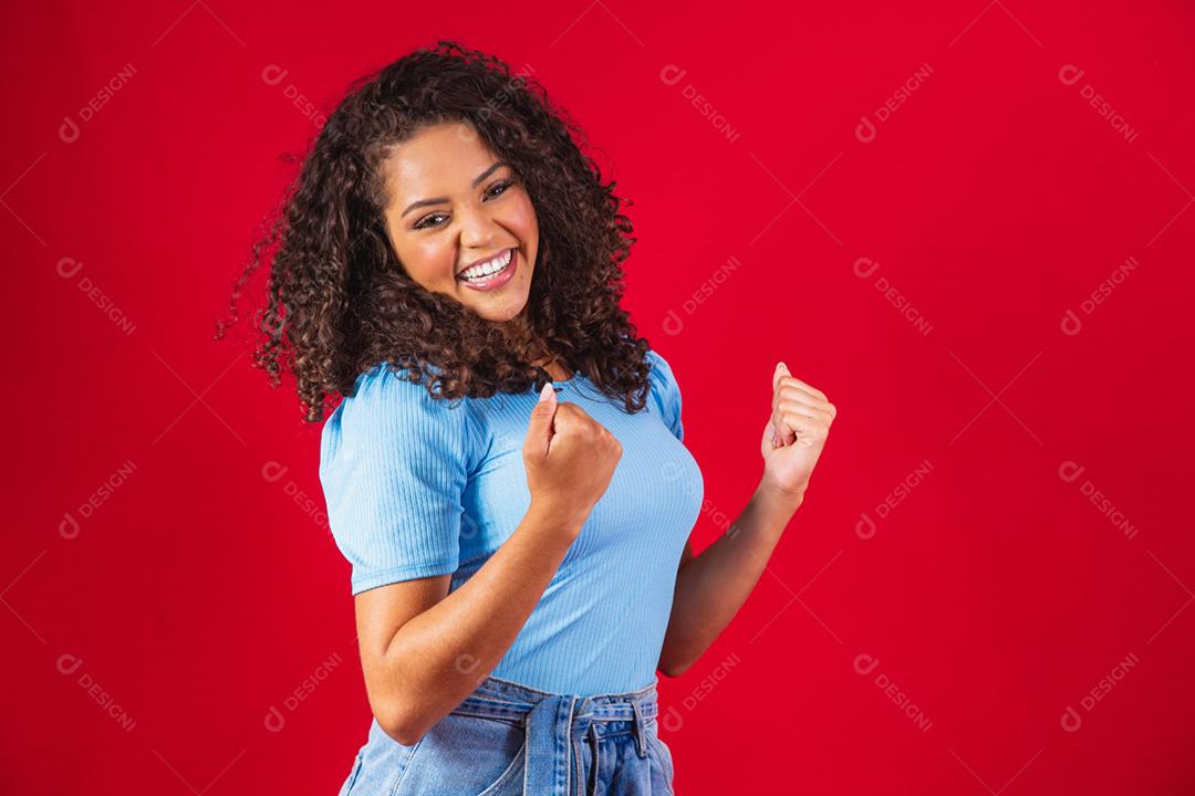 Jovem linda morena de cabelos cacheados regozijando-se alegremente dizendo