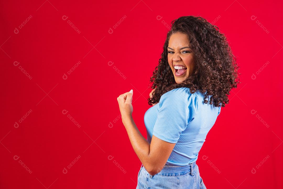Jovem linda morena de cabelos cacheados regozijando-se alegremente dizendo
