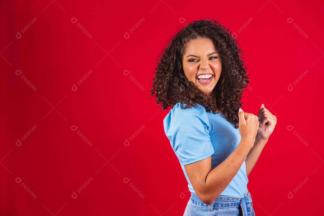 Jovem linda morena de cabelos cacheados regozijando-se alegremente dizendo
