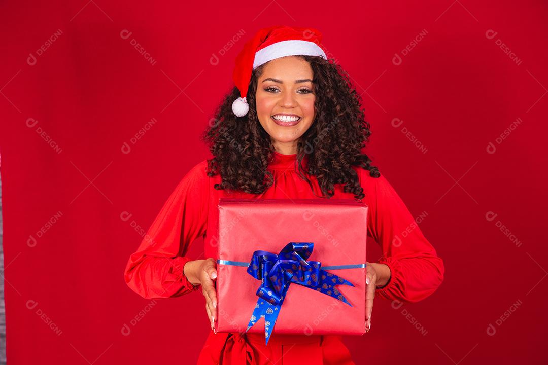 mulher linda cabelo cacheado usando chapeu papai noel segurando presente natal fotos imagem