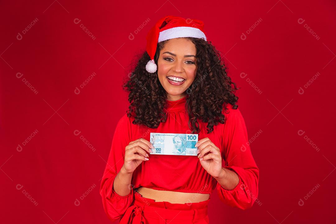 Mulher afro contando notas de dinheiro brasileiras. Notas reais. notas de 100 reais. Conceito de poupança para o final do ano