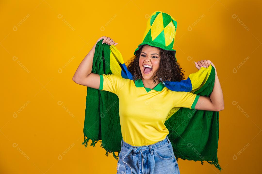 Garota afro torcendo pelo time brasileiro, segurando bandeira nacional