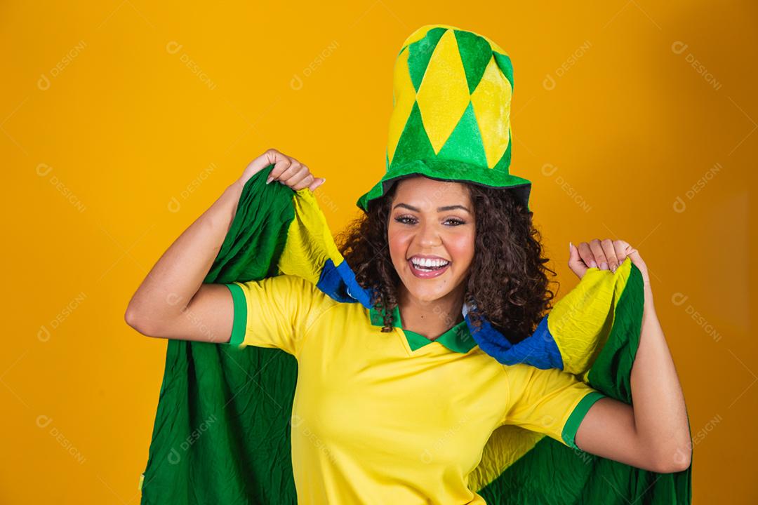 Garota afro torcendo pelo time brasileiro, segurando bandeira nacional