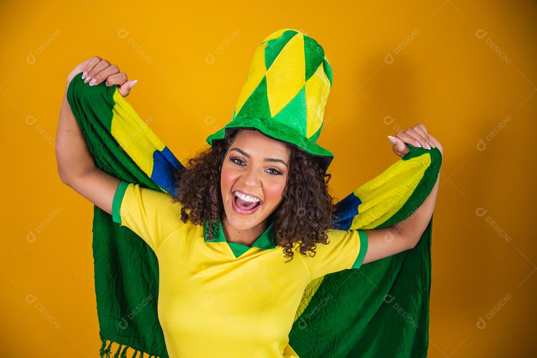 Garota afro torcendo pelo time brasileiro, segurando bandeira nacional