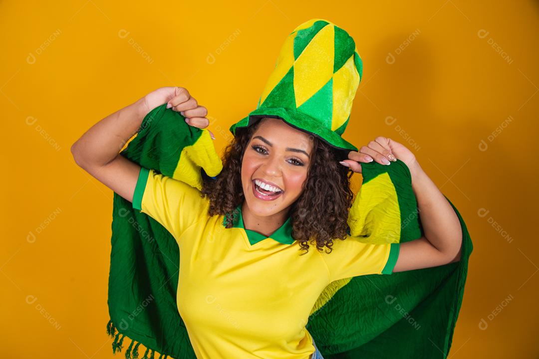 Garota afro torcendo pelo time brasileiro, segurando bandeira nacional