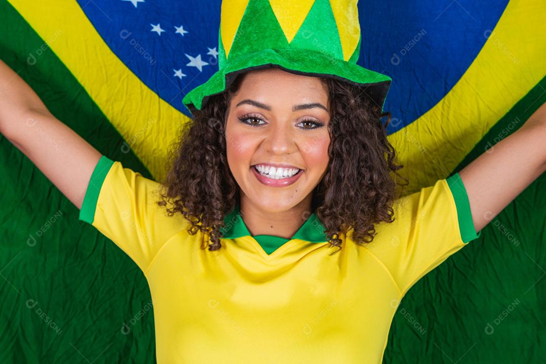 Garota afro torcendo pelo time brasileiro, segurando bandeira nacional