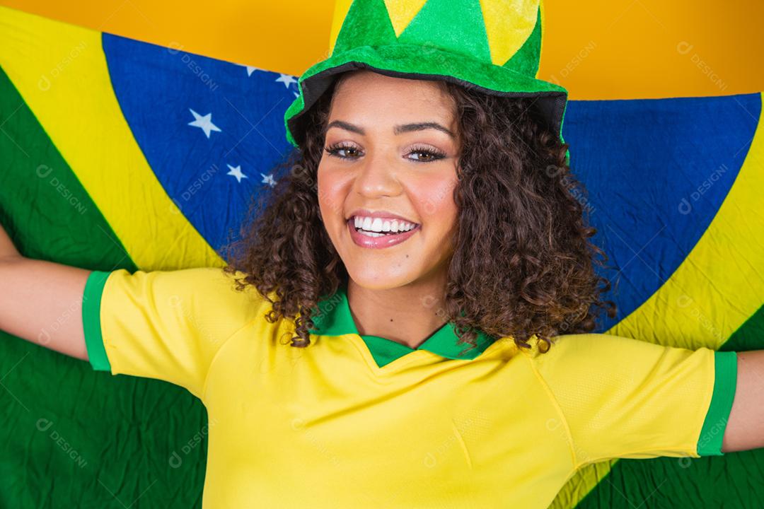 Garota afro torcendo pelo time brasileiro, segurando bandeira nacional