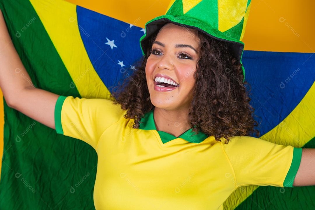 Garota afro torcendo pelo time brasileiro, segurando bandeira nacional