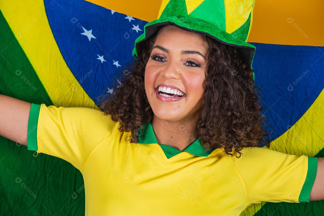 Garota afro torcendo pelo time brasileiro, segurando bandeira nacional