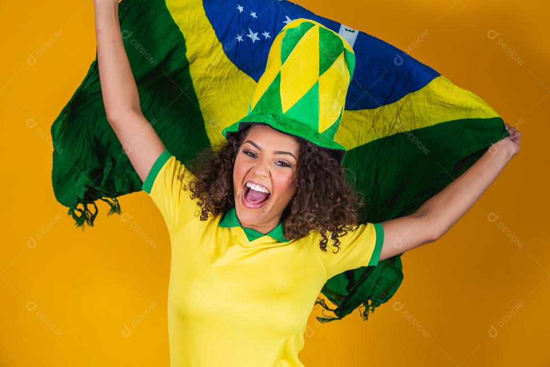 Garota afro torcendo pelo time brasileiro, segurando bandeira nacional