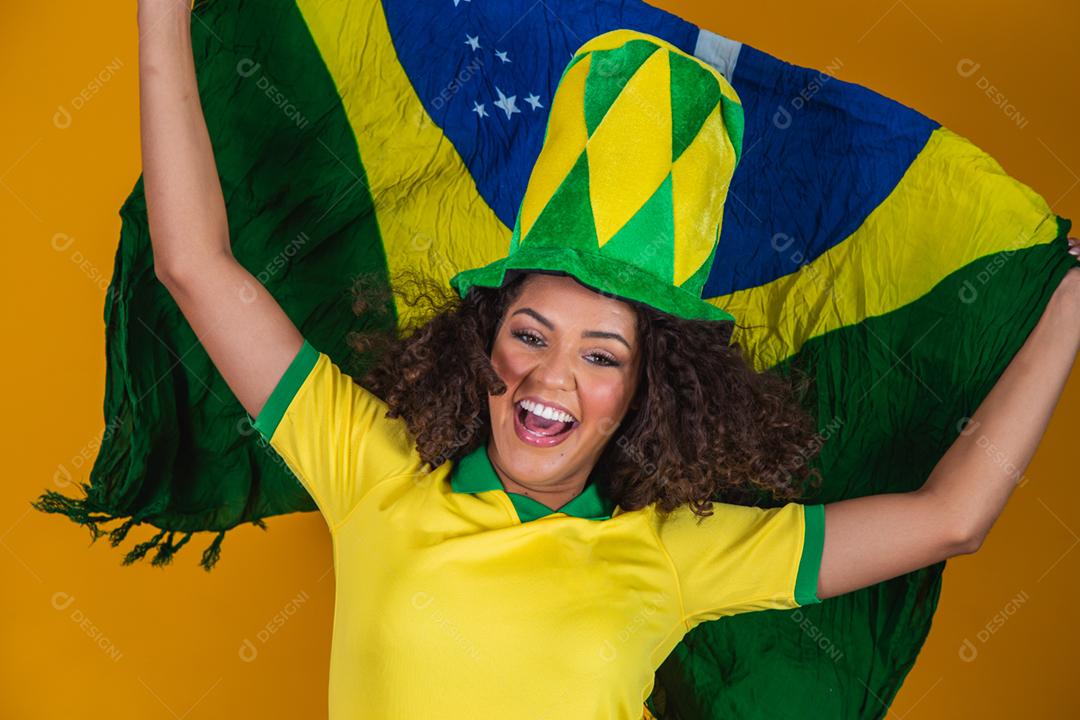 Garota afro torcendo pelo time brasileiro, segurando bandeira nacional