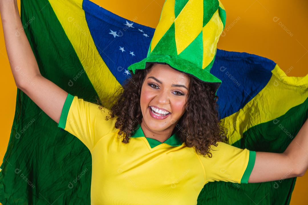 Garota afro torcendo pelo time brasileiro, segurando bandeira nacional