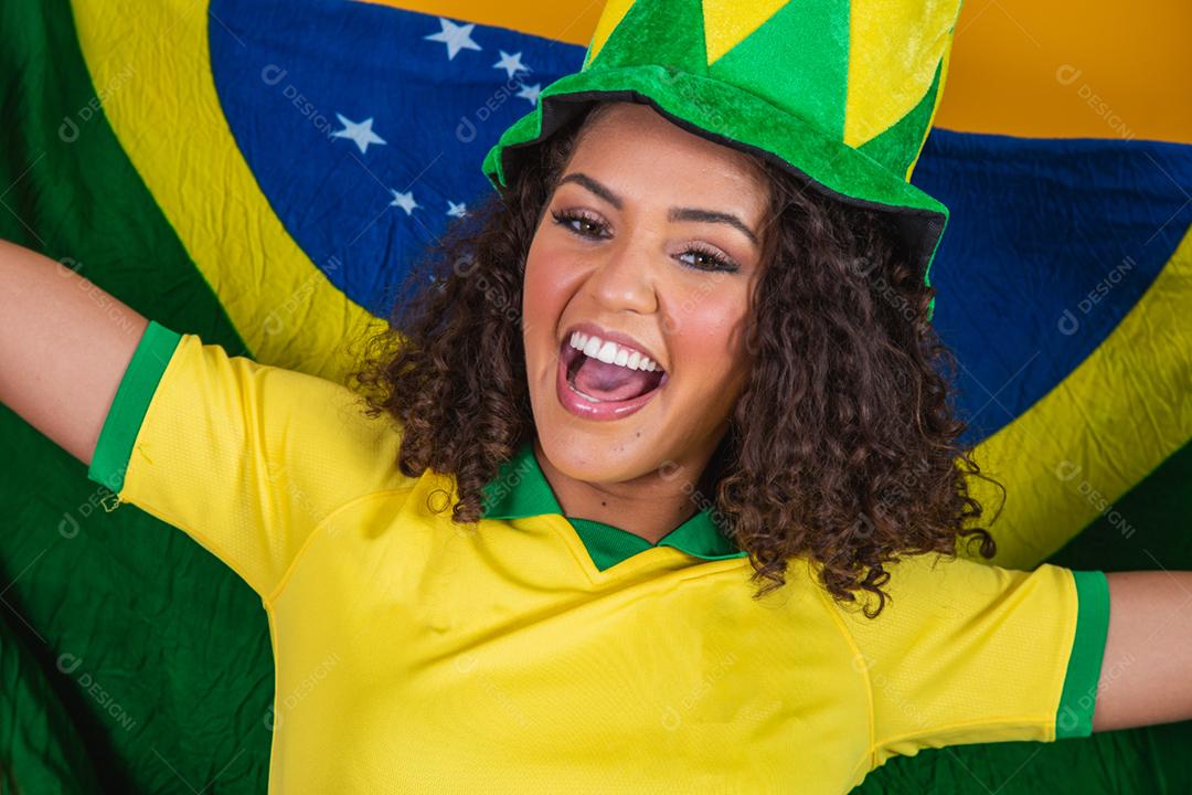 Garota afro torcendo pelo time brasileiro, segurando bandeira nacional