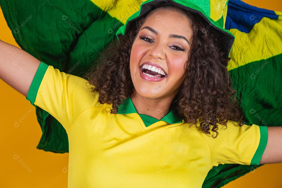 Garota afro torcendo pelo time brasileiro, segurando bandeira nacional