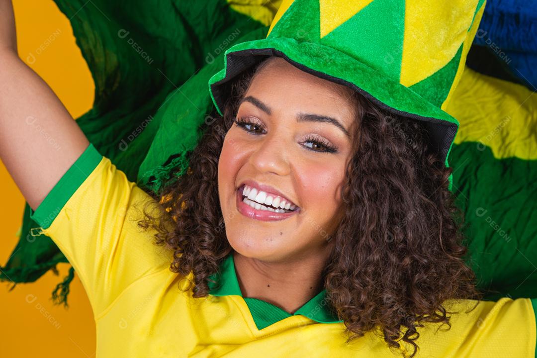 Garota afro torcendo pelo time brasileiro, segurando bandeira nacional