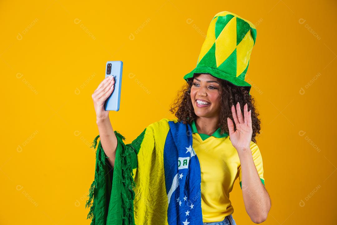 Garota afro torcendo pelo time brasileiro, segurando bandeira nacional