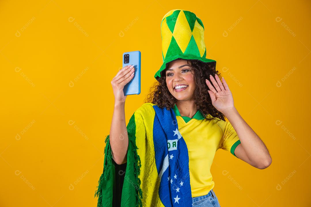 Garota afro torcendo pelo time brasileiro, segurando bandeira nacional