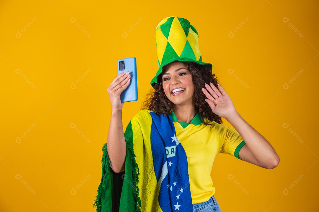 Garota afro torcendo pelo time brasileiro, segurando bandeira nacional