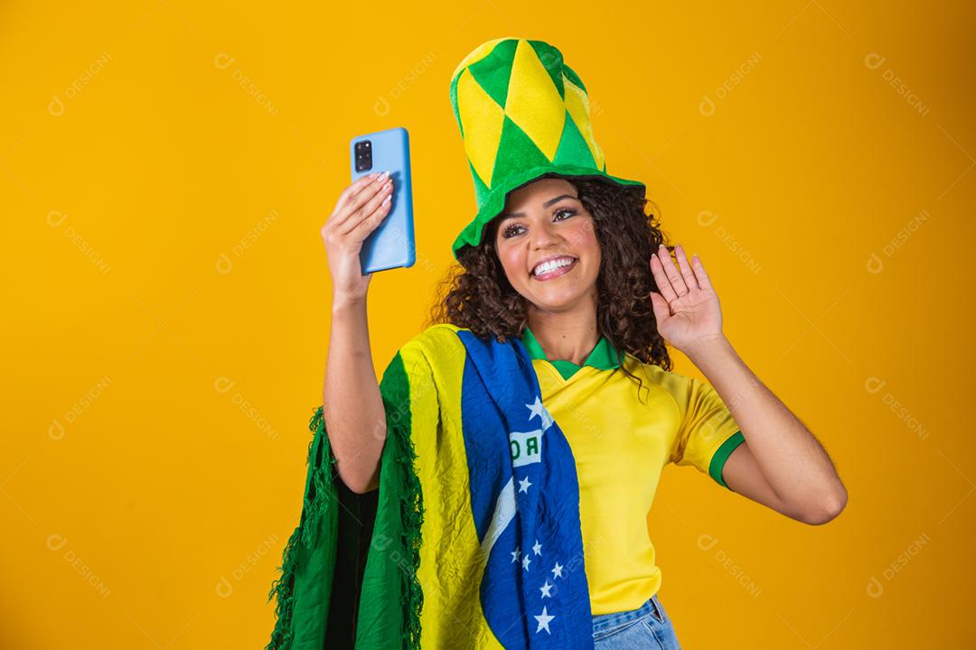 Garota afro torcendo pelo time brasileiro, segurando bandeira nacional