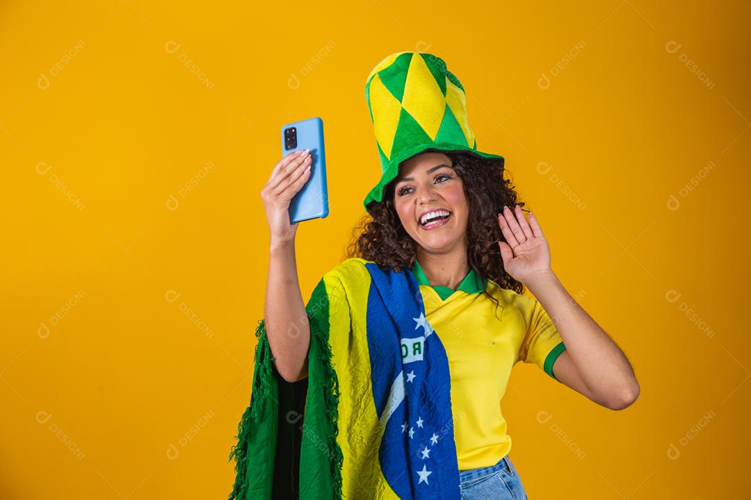 Garota afro torcendo pelo time brasileiro, segurando bandeira nacional