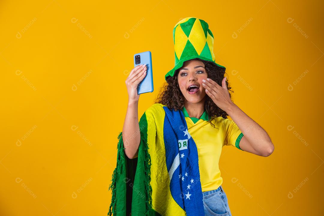 Garota afro torcendo pelo time brasileiro, segurando bandeira nacional