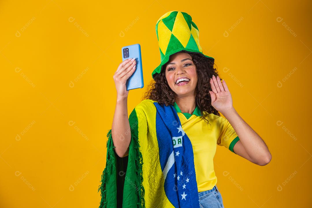 Garota afro torcendo pelo time brasileiro, segurando bandeira nacional